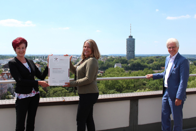 Verantwortliche der Stadtsparkasse Augsburg halten das Zertifikat zur Vereinbarkeit von Beruf und Familie.