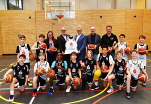 Umgeben von den Spielern der U12 der TSG Stadtbergen sind auf dem Bild zu sehen (v.l.n.r.): Sandra Peetz-Rauch (Vorstandsvorsitzende der Stadtsparkasse Augsburg), Uwe Hartung (2. Vorstand TSG Stadtbergen), Rainer Nauerz (Geschäftsführer der Stadtwerke Augsburg), Hans Kiesling (Abteilungsleiter Basketball der TSG Stadtbergen) und Stefan Goschenhofer (Sportlicher Leiter Nachwuchs TSG Stadtbergen).